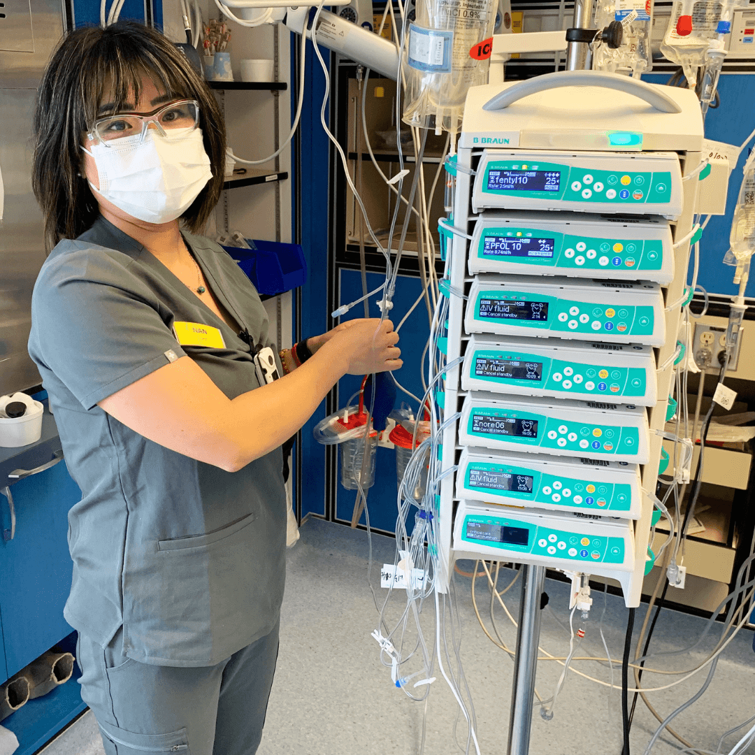Nurse using medical machine and looking at camera