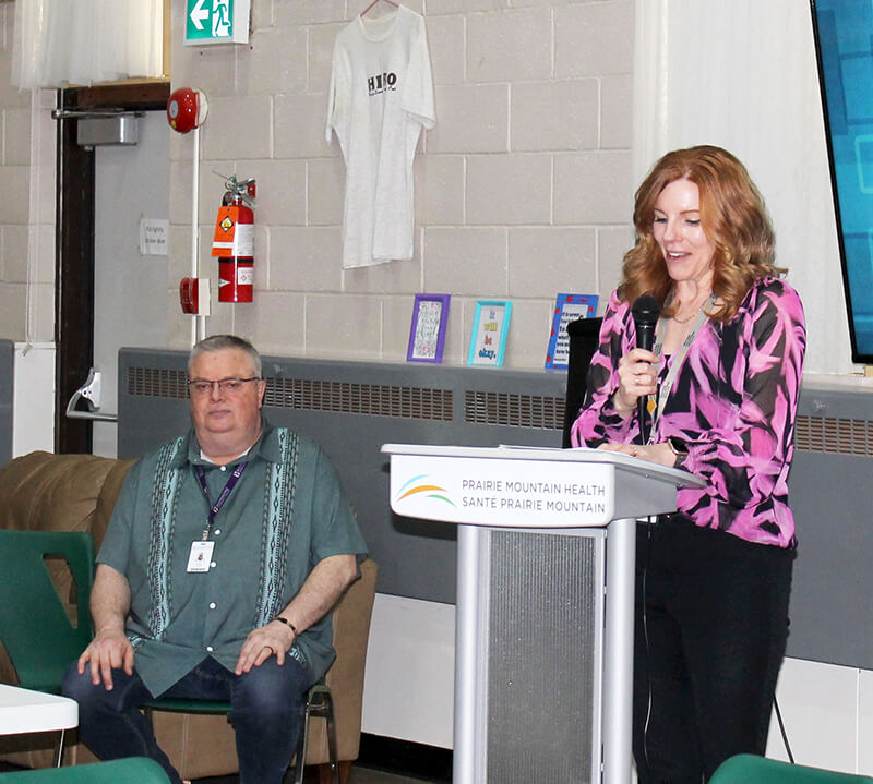 PMH CEO Treena Slate congratulates the Dauphin HERO Club for 30 inspiring years while community representative and former mental health worker Jim Price,  looks on.