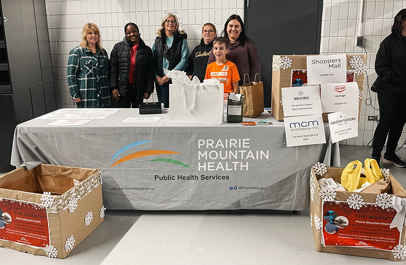 PMH Staff standing behind table, collecting mitts and toques
